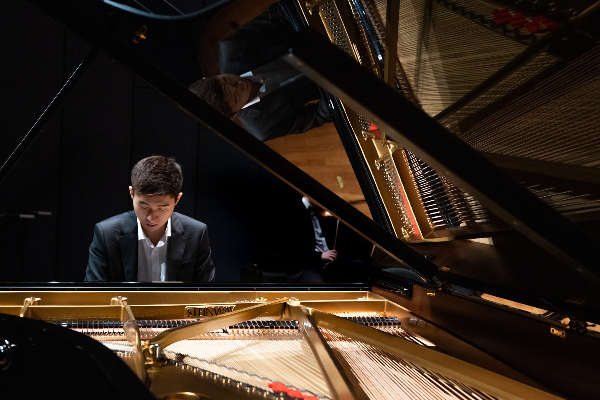 Samuel Choi performing at a grand piano on stage