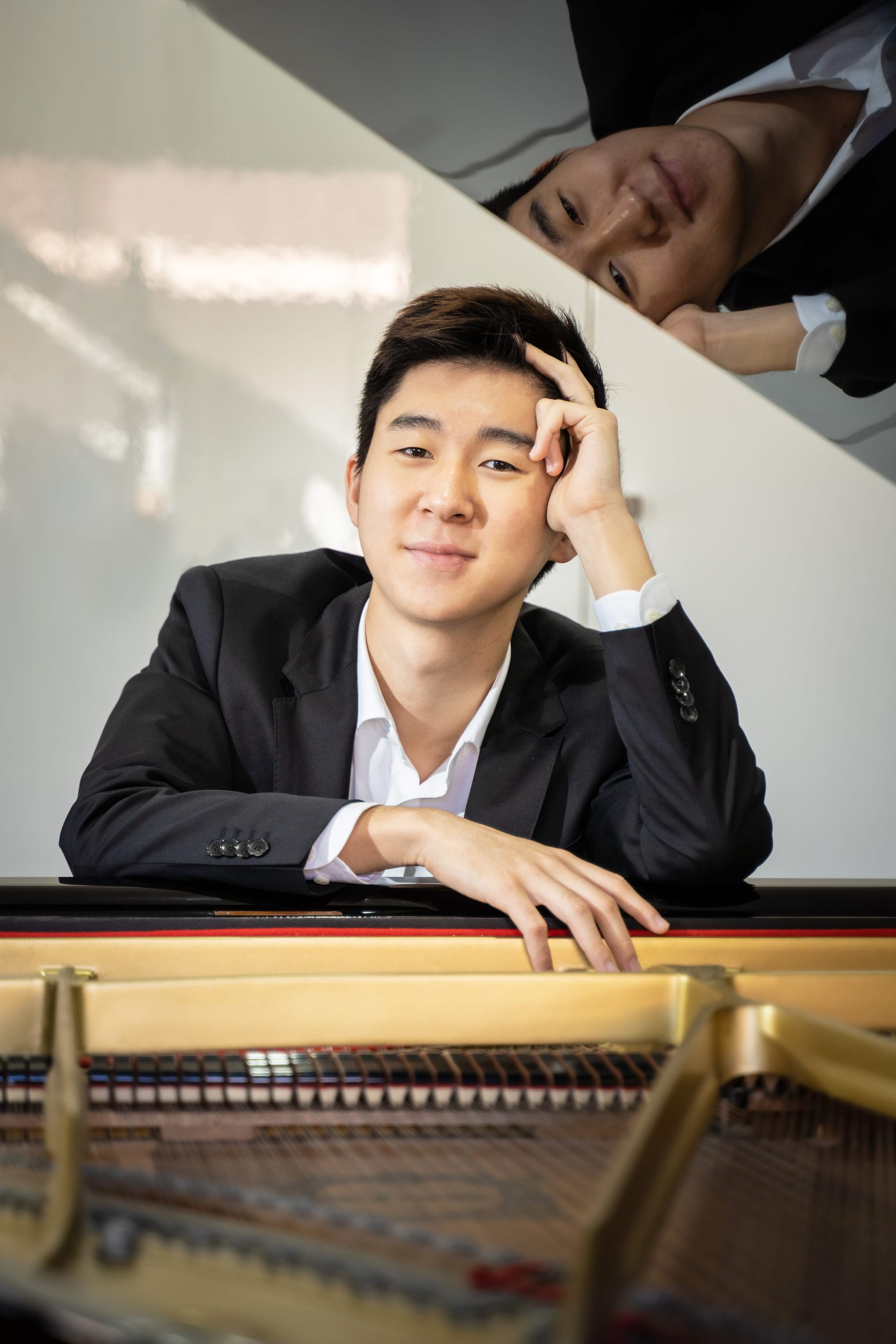 Portrait of Samuel Choi reflected in a piano lid